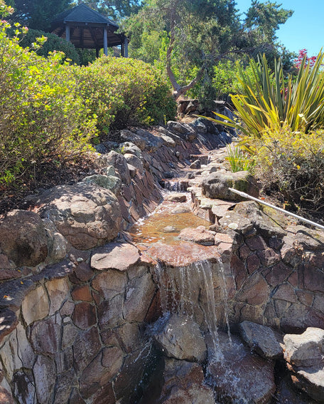 Rocky garden with a small waterfall and greenery